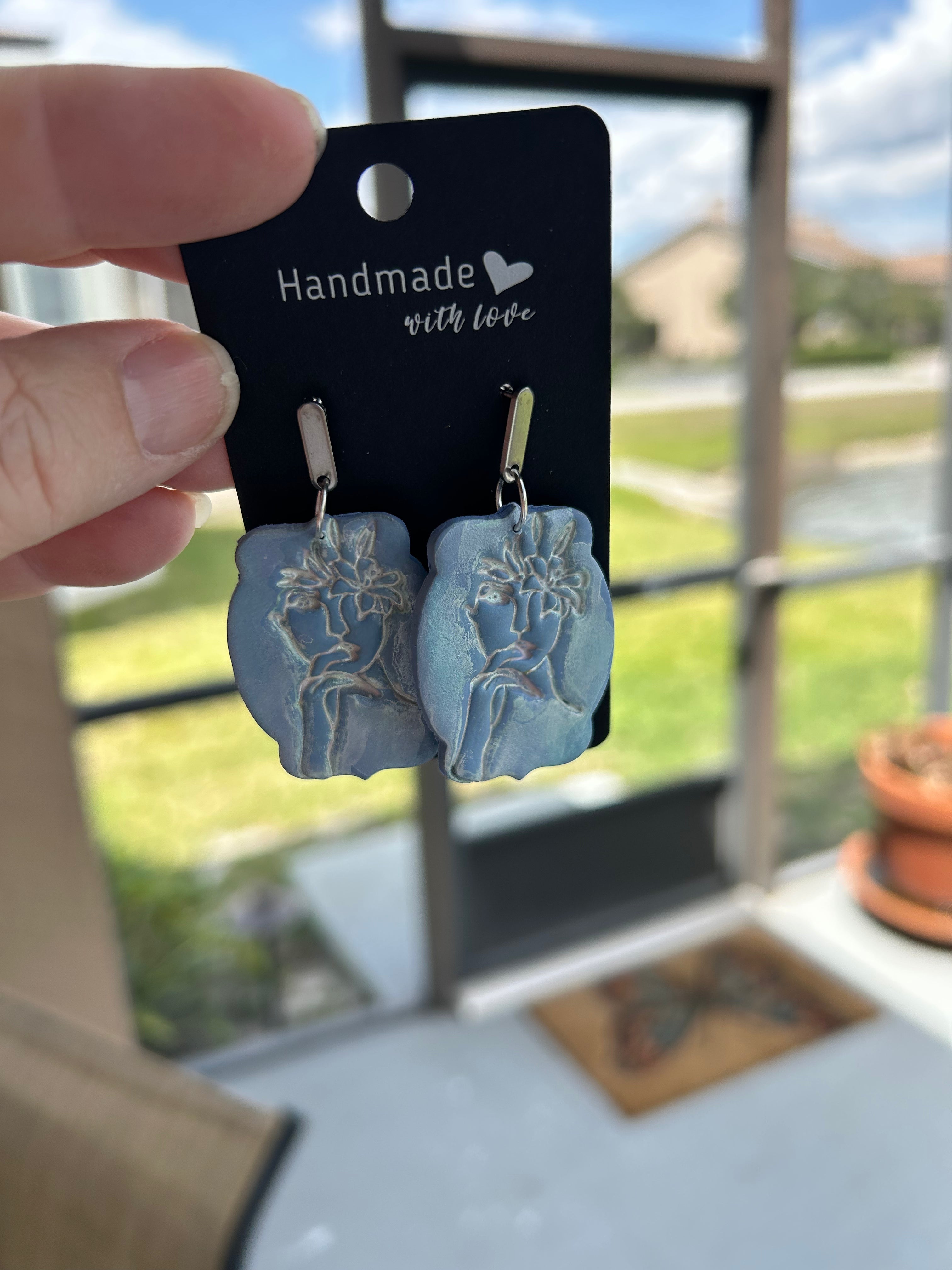 Blue dangle with face impression